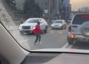 Pericol pe stradă: Un copil traversează printre mașini pentru a urca într-un vehicul staționat