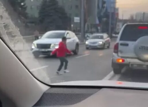 Pericol pe stradă: Un copil traversează printre mașini pentru a urca într-un vehicul staționat